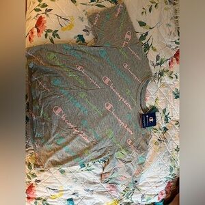 The colors displayed on the shirt are pink, light green, cyan blue, and gray.